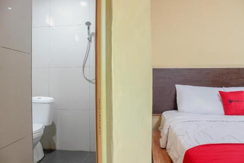 加拉旺RedDoorz Syariah near Pasar Modern Cikopo的一间卧室配有一张床,浴室设有卫生间