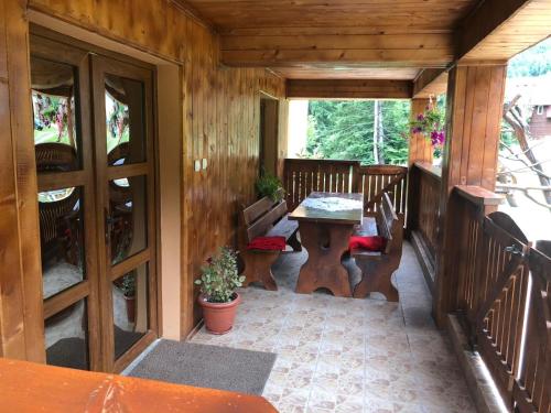 莫里河乡Cabana Cory Râușor的小屋的门廊配有桌椅