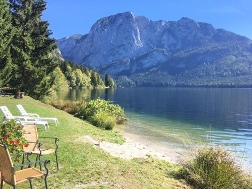 阿尔陶塞Hotel am See - Seeresidenz的坐在湖岸上的一排椅子