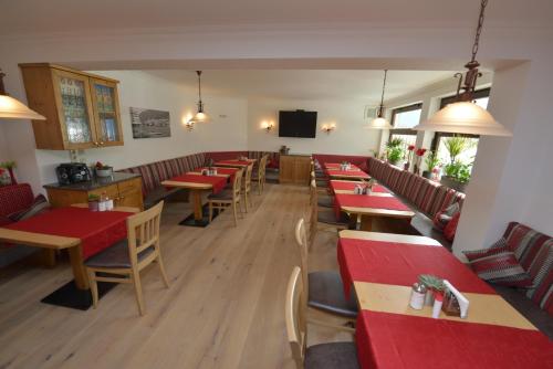 魏森湖霍斯比特酒店的餐厅设有木桌、椅子和红色桌子。