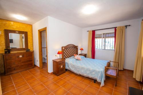 科因Cubo´s Casa Rural La Cañada de Coín的一间卧室配有一张床、梳妆台和镜子