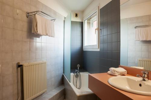 维金勒科吉特Kyriad Direct Rennes Ouest的浴室配有盥洗盆、卫生间和浴缸。