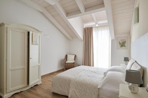 切里亚莱Agriturismo Casastella的白色的卧室设有床和窗户
