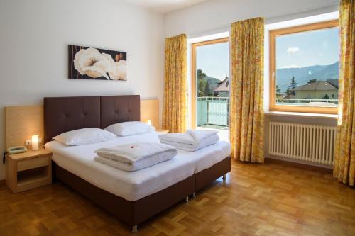 梅拉诺菲力品诺姆酒店的一间卧室设有一张床和一个大窗户