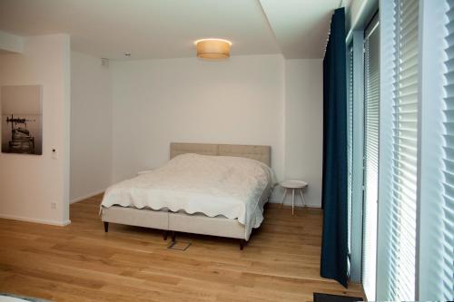 派尔努Riverside Apartment的一间卧室配有一张床,铺有木地板