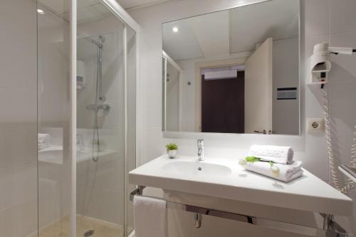 巴塞罗那圣家堂酒店的白色的浴室设有水槽和淋浴。