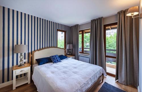 班斯科Predela LUX Aparthotel的一间卧室设有一张床和一个大窗户