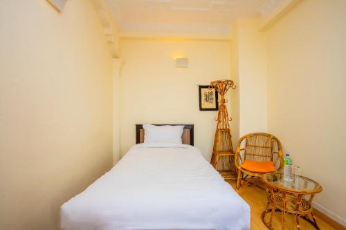 巴克塔普尔Welcome Heritage Inn的卧室配有1张床、1张桌子和1把椅子