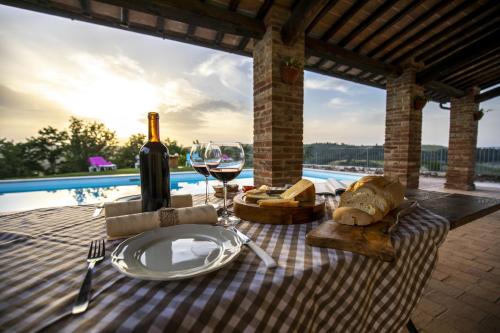 阿夏诺La Coppa的一张野餐桌,上面放着一杯葡萄酒和奶酪