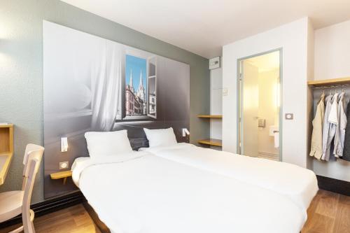 巴约讷B&B HOTEL Bayonne的卧室配有一张白色大床和一个衣柜