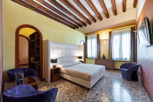 威尼斯阿巴西亚德豪华酒店的一间卧室配有一张床和两把椅子
