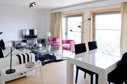 里斯本全景生活公寓的客厅配有白色沙发和粉红色椅子