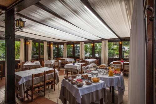 曼德洛德拉廖Hotel Al Verde的用餐室配有带白色桌布的桌子