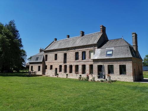 IngouvilleManoir des Carreaux Chambres d'hôtes的草地上一座大型砖砌建筑