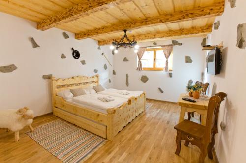 JasenicaZbojnicky penzion的一间卧室配有一张木床和一张桌子