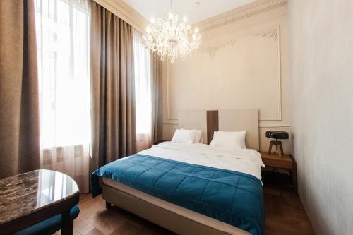 伊尔库茨克Hotel Amurskiy的一间卧室配有一张大床和一个吊灯。