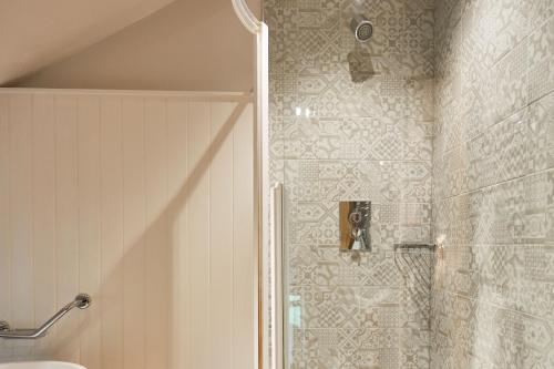 马勒姆利斯特亚姆斯宾馆的浴室里设有玻璃门淋浴