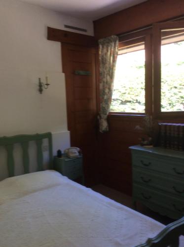AngresseChez Uli的一间卧室配有一张床、一个梳妆台和一扇窗户。