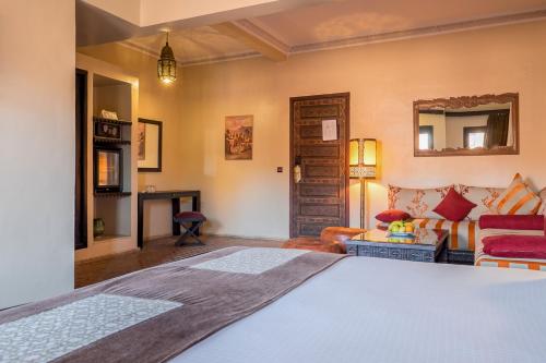 马拉喀什马拉喀什希沃纳吉旁摩洛哥传统庭院住宅的一间卧室设有一张床和一间客厅。