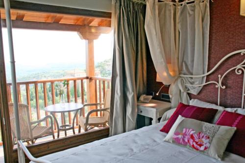 阿尔克萨尔Hotel Castillo的一间卧室配有一张床,阳台配有桌子