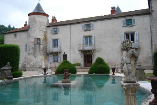 Olliergues尚特劳兹城堡酒店的建筑前有喷泉的庄园