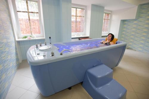斯维诺乌伊希切埃利斯旅馆的坐在浴室蓝色浴缸中的女人
