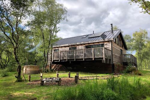 Dallavich奥赛湖景山林小屋的小木屋设有门廊和甲板