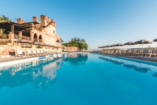 卡斯泰尔诺沃马格拉伊波图中世纪度假酒店的大楼前的蓝色海水游泳池