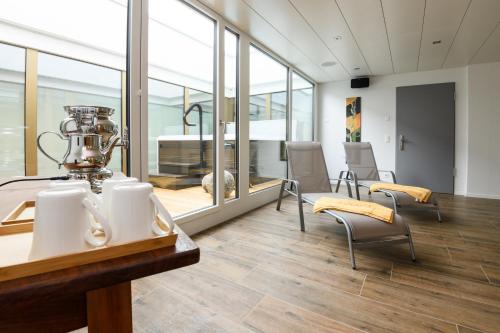 措芬根Partner Hotel AG Zofingen的大房间设有桌椅和玻璃墙