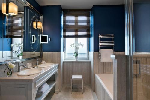 迪纳尔Hôtel Barrière Le Grand Hôtel Dinard的浴室设有2个水槽、浴缸和镜子