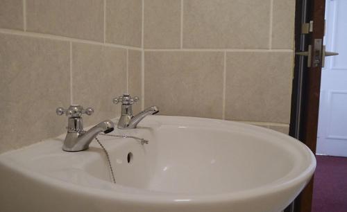 彭赞斯联盟酒店的浴室内带两个水龙头的白色水槽