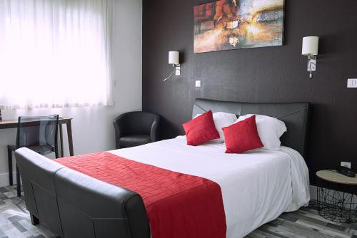 昂古莱姆Cit'Hotel Europeen的一间卧室配有一张带红色枕头的大床