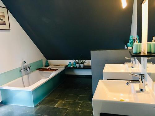 默讷塞Apartment Urlaubsrausch am Möhnesee的浴室配有两个盥洗盆和浴缸。