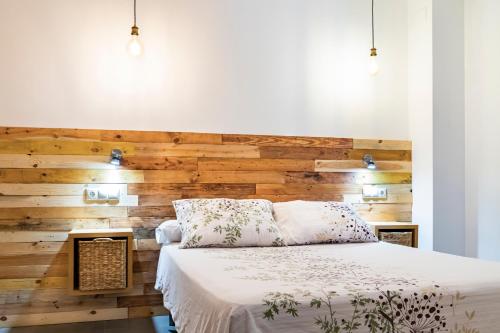 乌贝达Alojamiento San Nicolas的一间卧室设有木墙和一张床