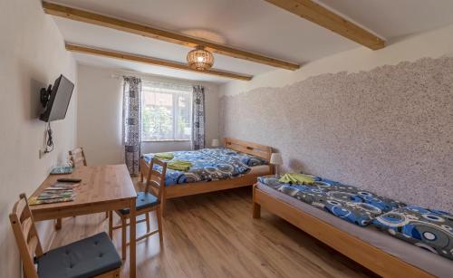 Brod nad DyjíBerunka的客房设有两张床、一张桌子和一张书桌。