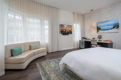 迈阿密海滩马林酒店的一间卧室配有一张大床和一张沙发