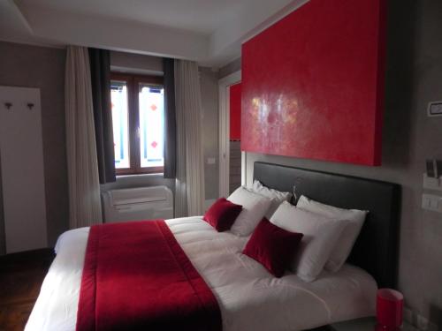 弗拉斯卡蒂根特迪诺特宾馆的一间卧室配有一张带红色和白色枕头的大床