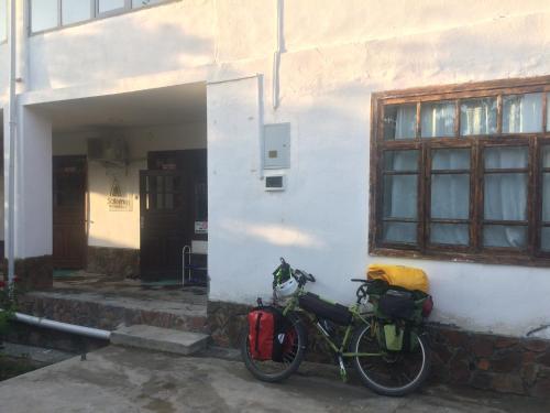 PanjakentSalom Hostel的停在白色建筑旁边的自行车