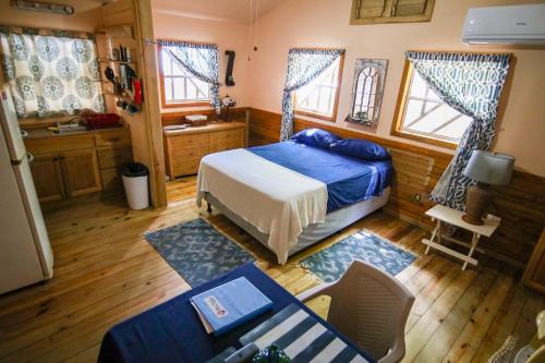 桑迪湾Blue Island Divers Casita Azul的卧室配有一张床和一张桌子及椅子