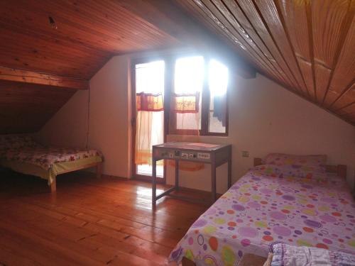乌日策Guest house Little Heaven的一间卧室配有一张床、一张桌子和一个窗户。