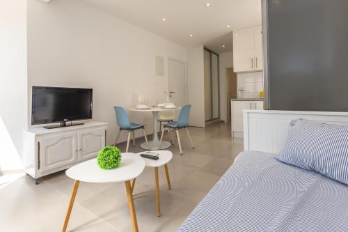 马卡尔斯卡Luxury apartments Nikolina Sea&City view的客厅配有沙发、电视和桌子