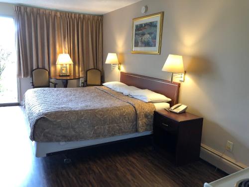卡尔加里Travellers Inn的酒店客房配有一张床和电话