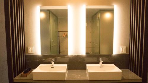 座间味村Blue Suites Hanamuro的一间带两个盥洗盆和大镜子的浴室