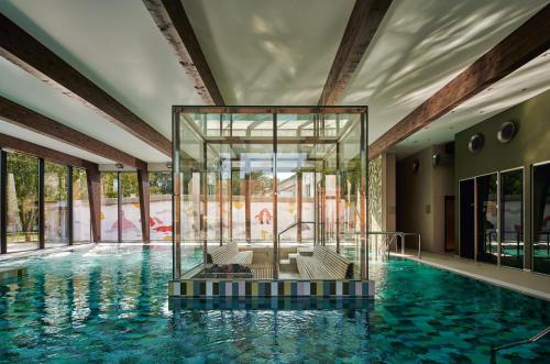 派尔努Wasa Resort Hotel, Apartments & SPA的一座带玻璃盒的游泳池