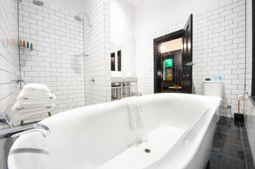 阿德莱德富兰克林精品酒店的白色的浴室设有浴缸和水槽。