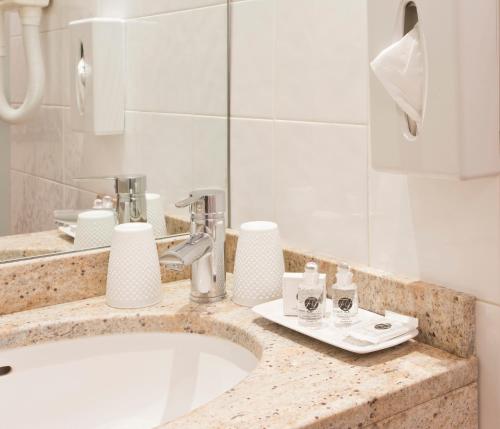 巴黎杜克丹鲁酒店的浴室的柜台设有水槽和镜子