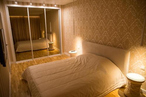 维尔纽斯Antakalnis 5 stars apartment的一间卧室配有一张床和一面大镜子