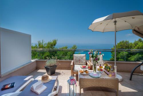 马卡尔斯卡海洋酒店的一个带桌子和遮阳伞的庭院和大海