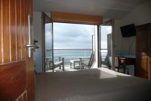 孔卡尔诺柯默尔酒店的一间卧室配有一张床,享有海景