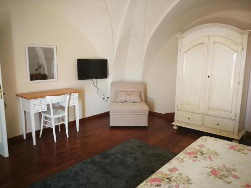 乌真托Palazzo Novecento的客房设有书桌、桌子和椅子。